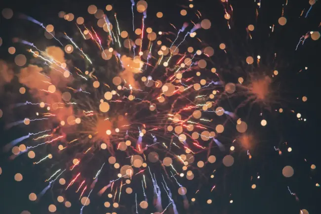 Photo by Erwan Hesry Bright colorful fireworks exploding in the night sky with a soft bokeh effect